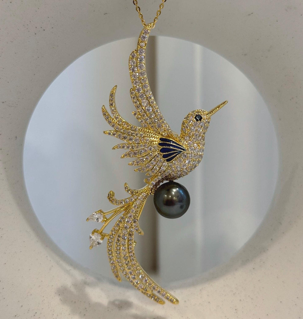 Bird brooch pendant featuring a genuine Tahitian black saltwater pearl with mirror luster.