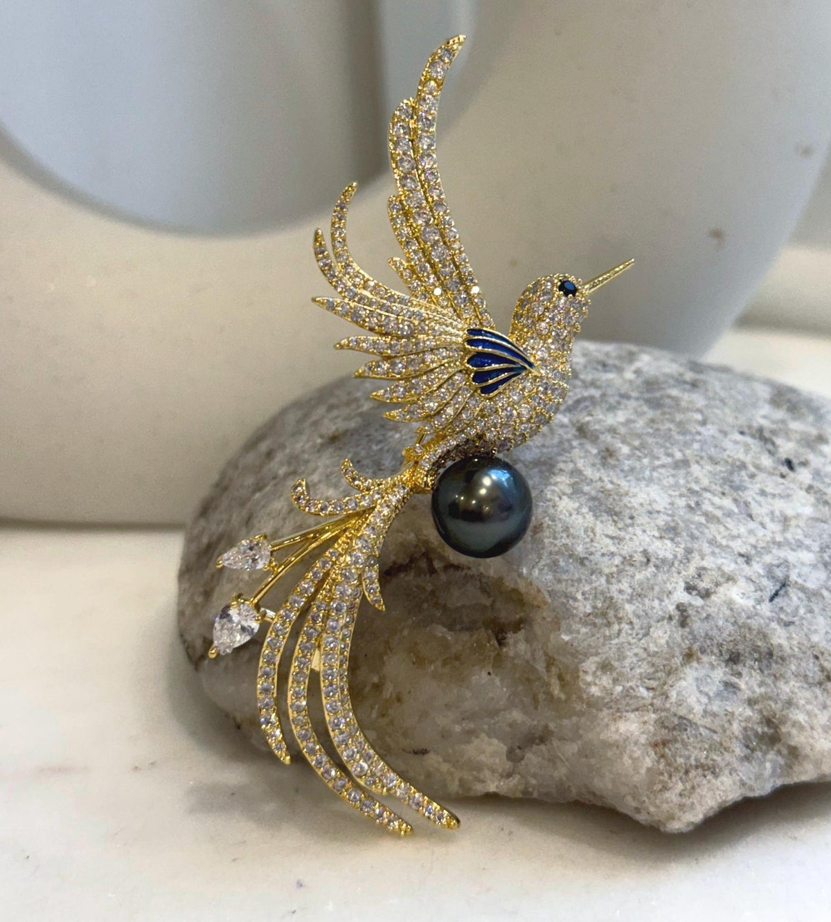 Decorative bird design with a lustrous black Tahitian pearl, wearable as a brooch or pendant.