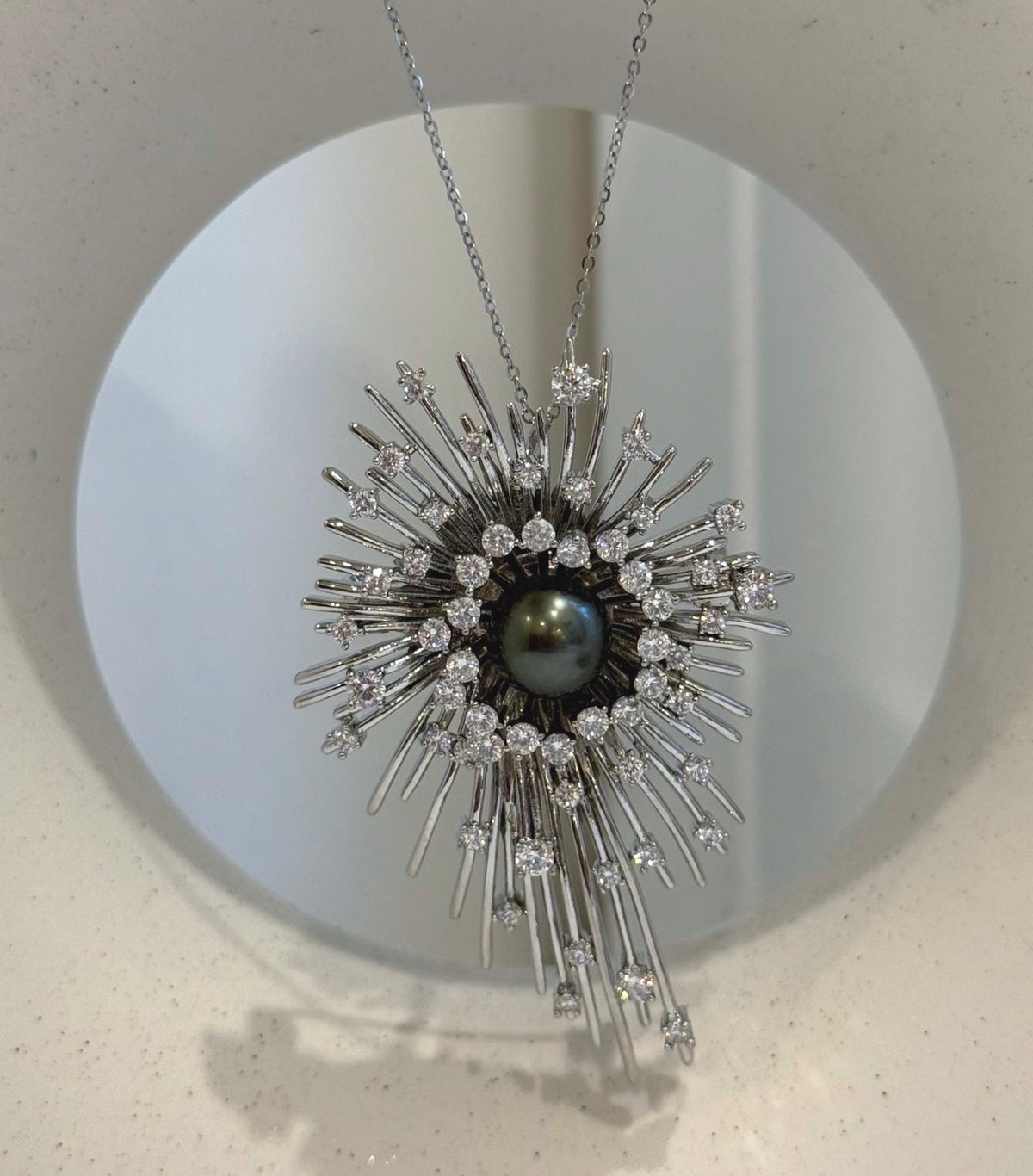 Starburst brooch featuring a lustrous genuine black Tahitian saltwater pearl