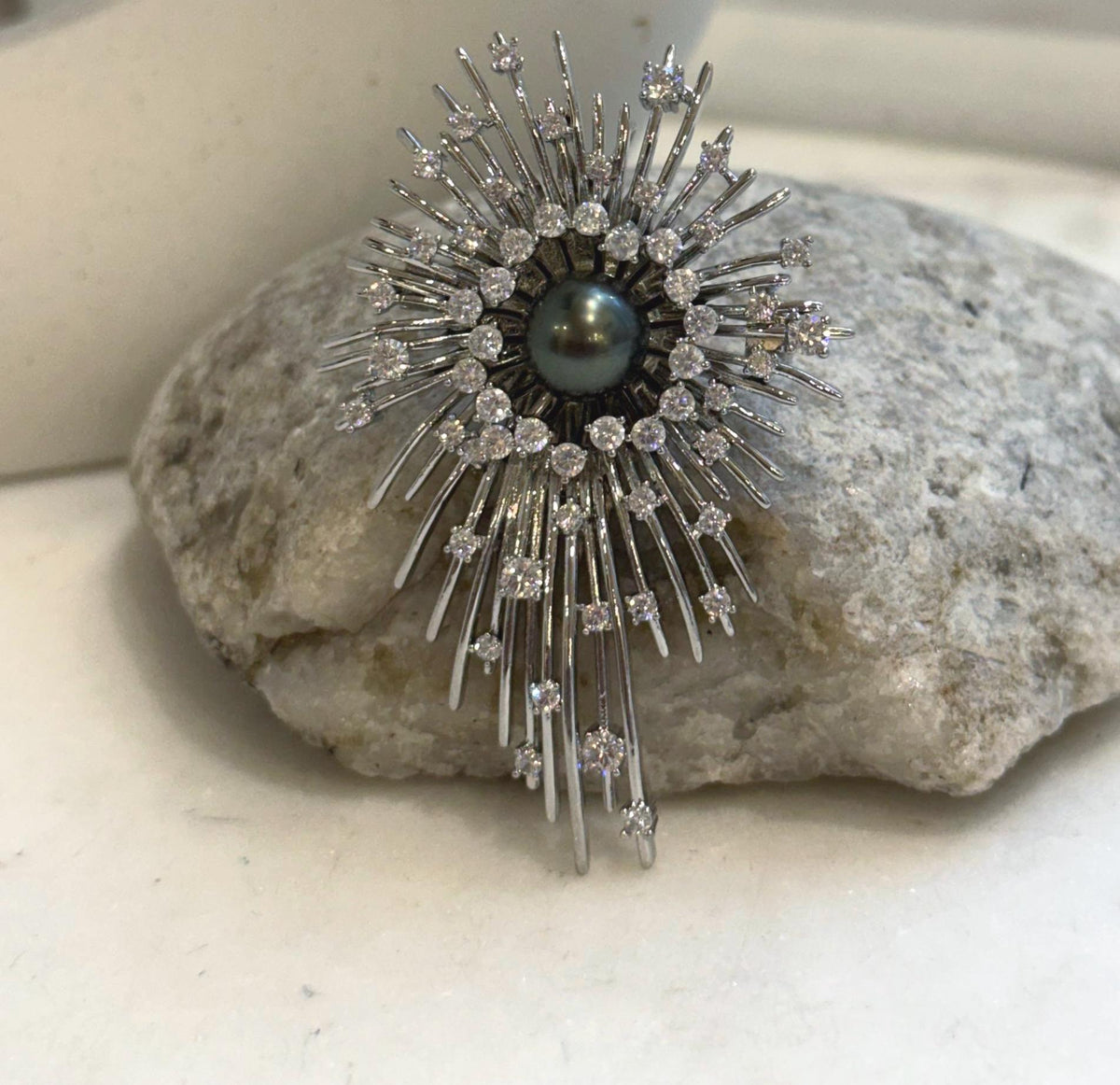 Two-in-one starburst brooch and pendant featuring a black Tahitian pearl