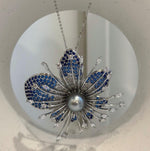 Decorative flower brooch with blue accents ranging from bright blue to navy.