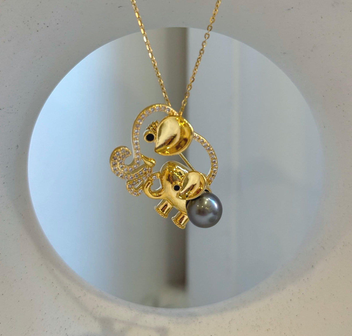 Mother and baby elephant brooch with a lustrous dark gray Tahitian pearl.