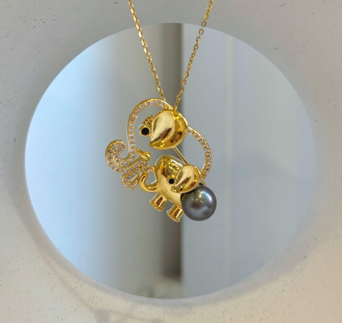Elephant family brooch featuring an openwork design outlined with clear sparkling stones.
