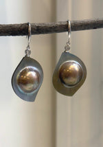 Golden mabe pearl earrings with rainbow overtones and mirror luster.