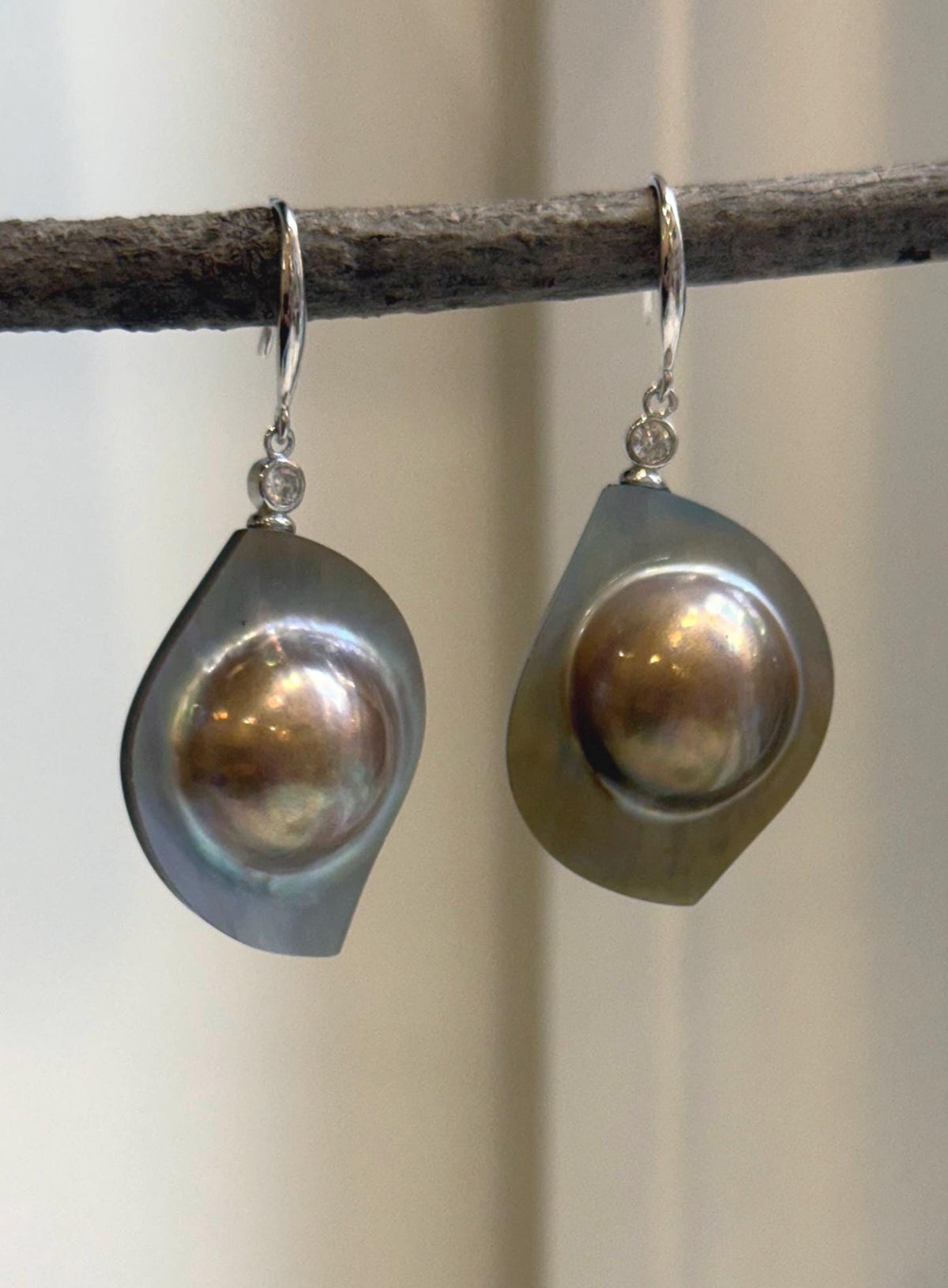 Rainbow iridescent mabe pearls set in sterling silver drop earrings.