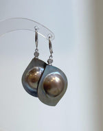 Golden mabe pearl statement earrings with a mirror-like sheen.