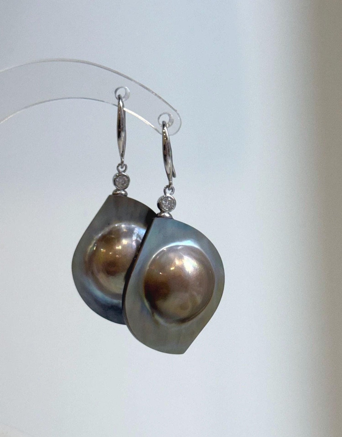 Golden mabe pearl statement earrings with a mirror-like sheen.