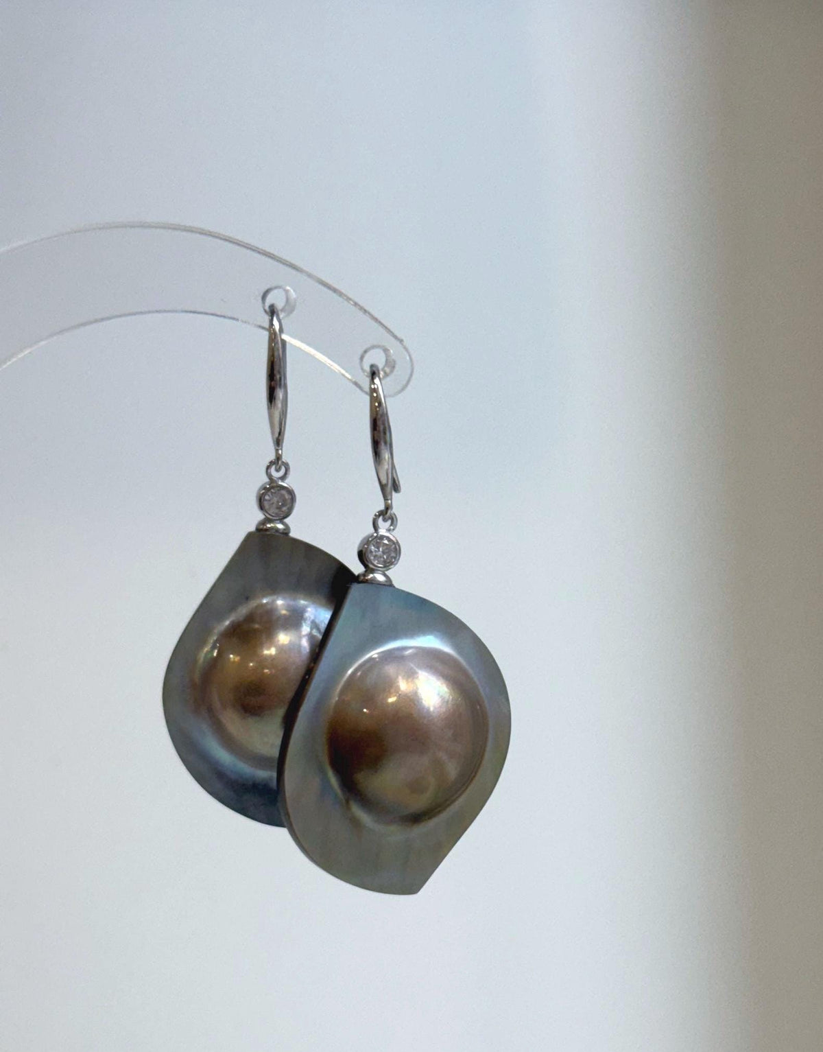 Iridescent golden mabe pearl drops framed in sterling silver.