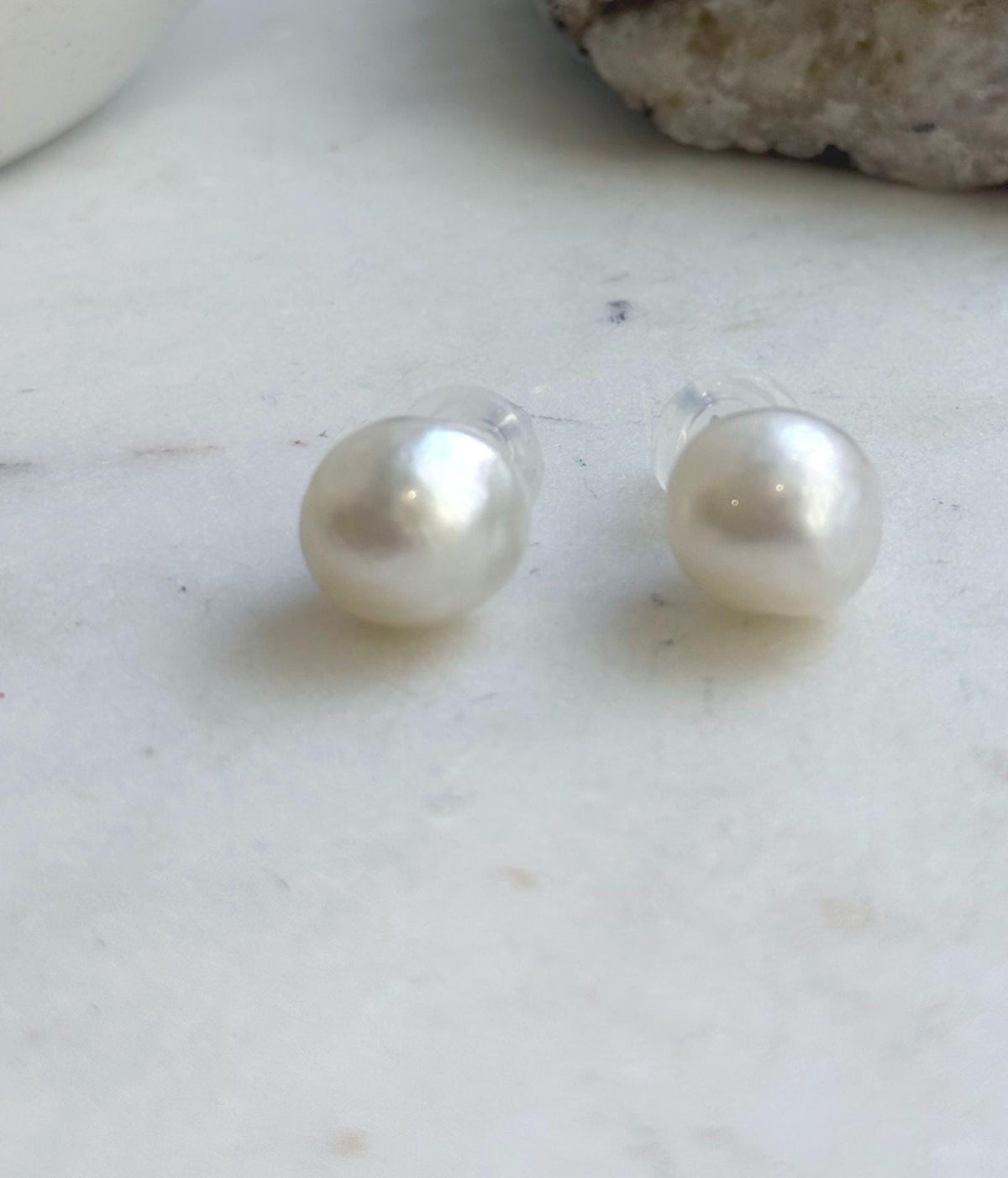 Australian South Sea pearl studs showcasing bright reflections and soft white tones.