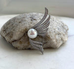 White Edison pearl brooch pendant with sweeping silver-tone wings and sparkling stone accents.