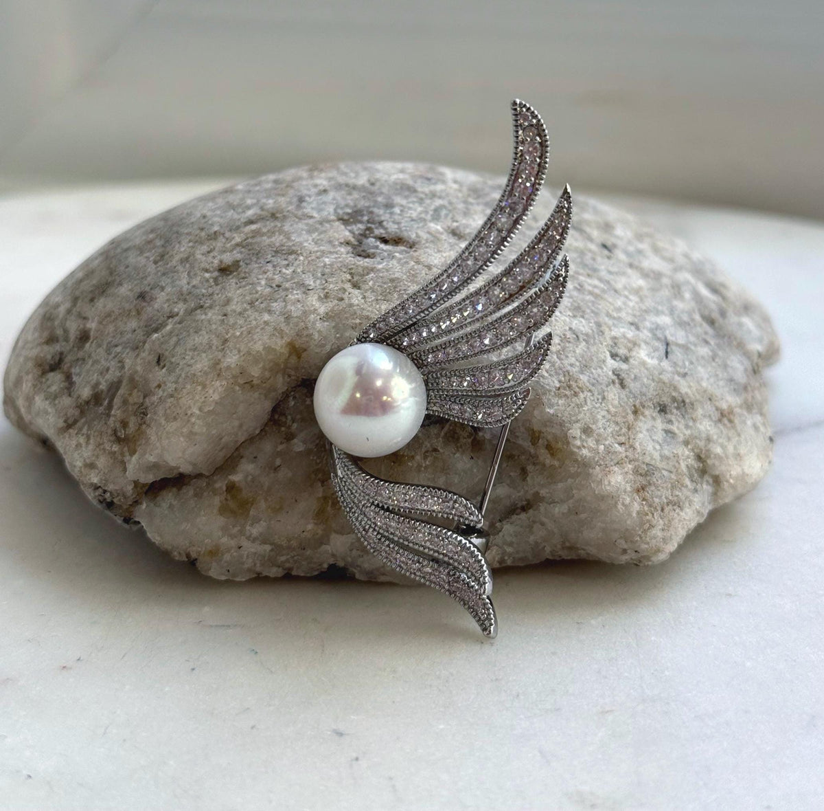 Two-in-one Edison pearl brooch and pendant with an elegant wing design.