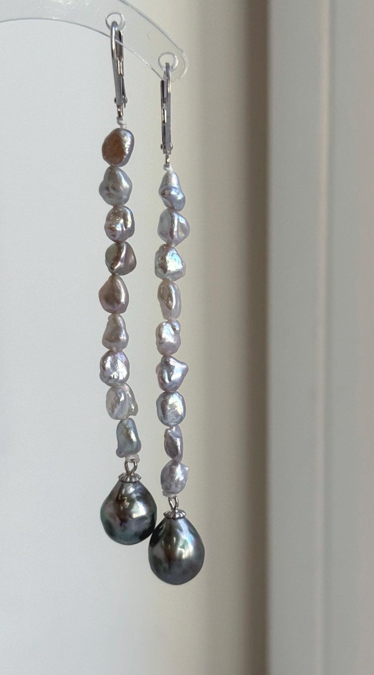 Sterling silver chandelier earrings featuring genuine green Tahitian pearls.