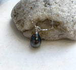 Dark Tahitian pearl pendant with colorful reflections and a curved sterling silver centerpiece.