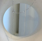 Teardrop Tahitian pearl with mirror luster suspended from a silver knot necklace.