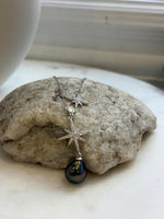 Silver Y necklace with two starburst motifs and a lustrous Tahitian saltwater pearl.