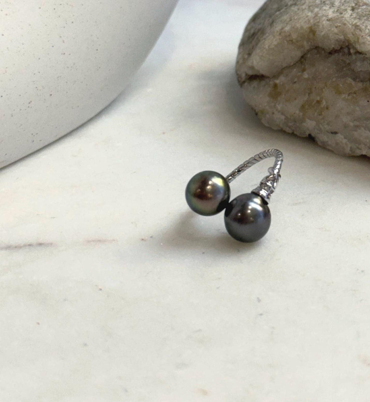 Minimalist sterling silver ring showcasing two Tahitian pearls with mirror luster.