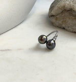 Minimalist sterling silver ring showcasing two Tahitian pearls with mirror luster.
