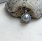 Tahitian saltwater pearl necklace featuring a circular crystal halo and a teardrop-shaped bail.