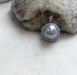 Large pearl statement necklace with a crystal-accented halo and matching silver bail.
