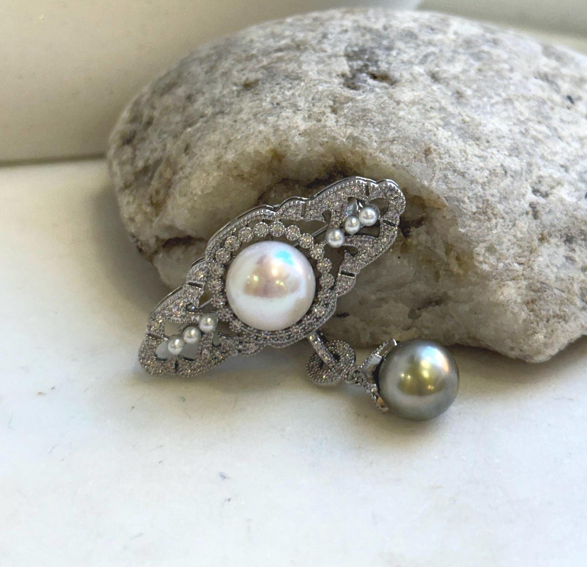 Edison pearl brooch pendant with a luminous white center pearl and dark pearl drop