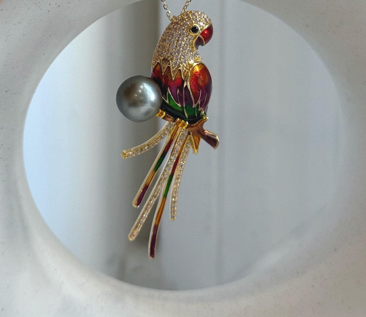 Genuine Tahitian pearl incorporated into a multicolor enamel parrot design.