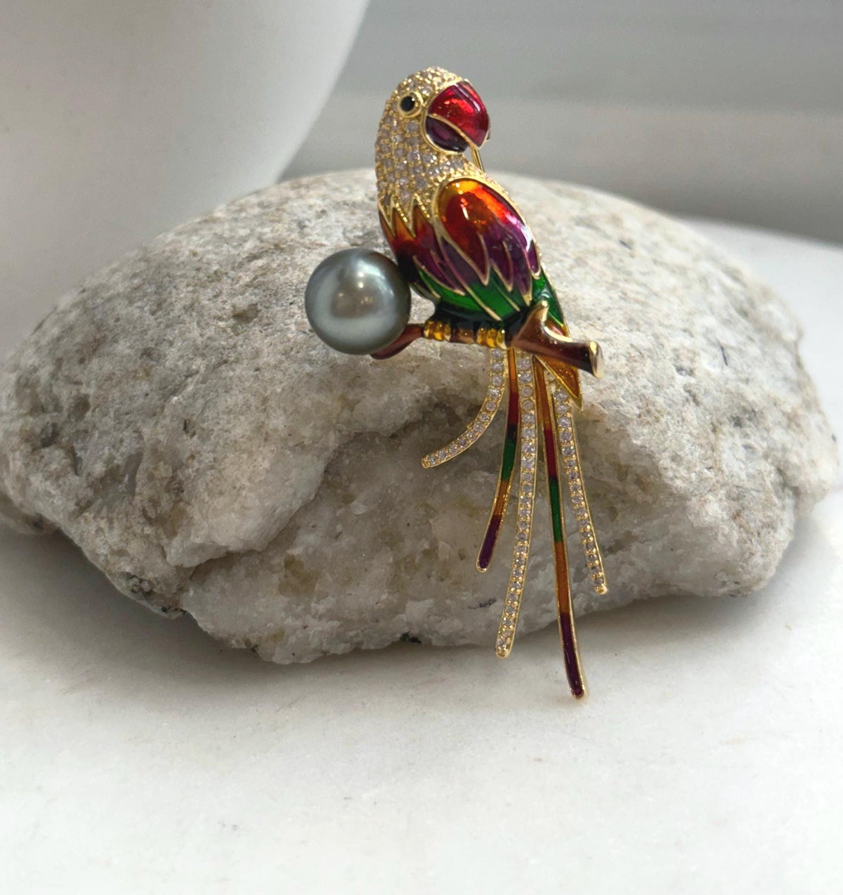 Gold-tone parrot brooch pendant accented with colorful enamel and a saltwater pearl.