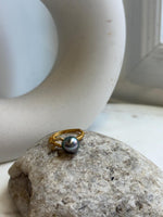 Peacock green Tahitian pearl ring shown beside its handwritten size label