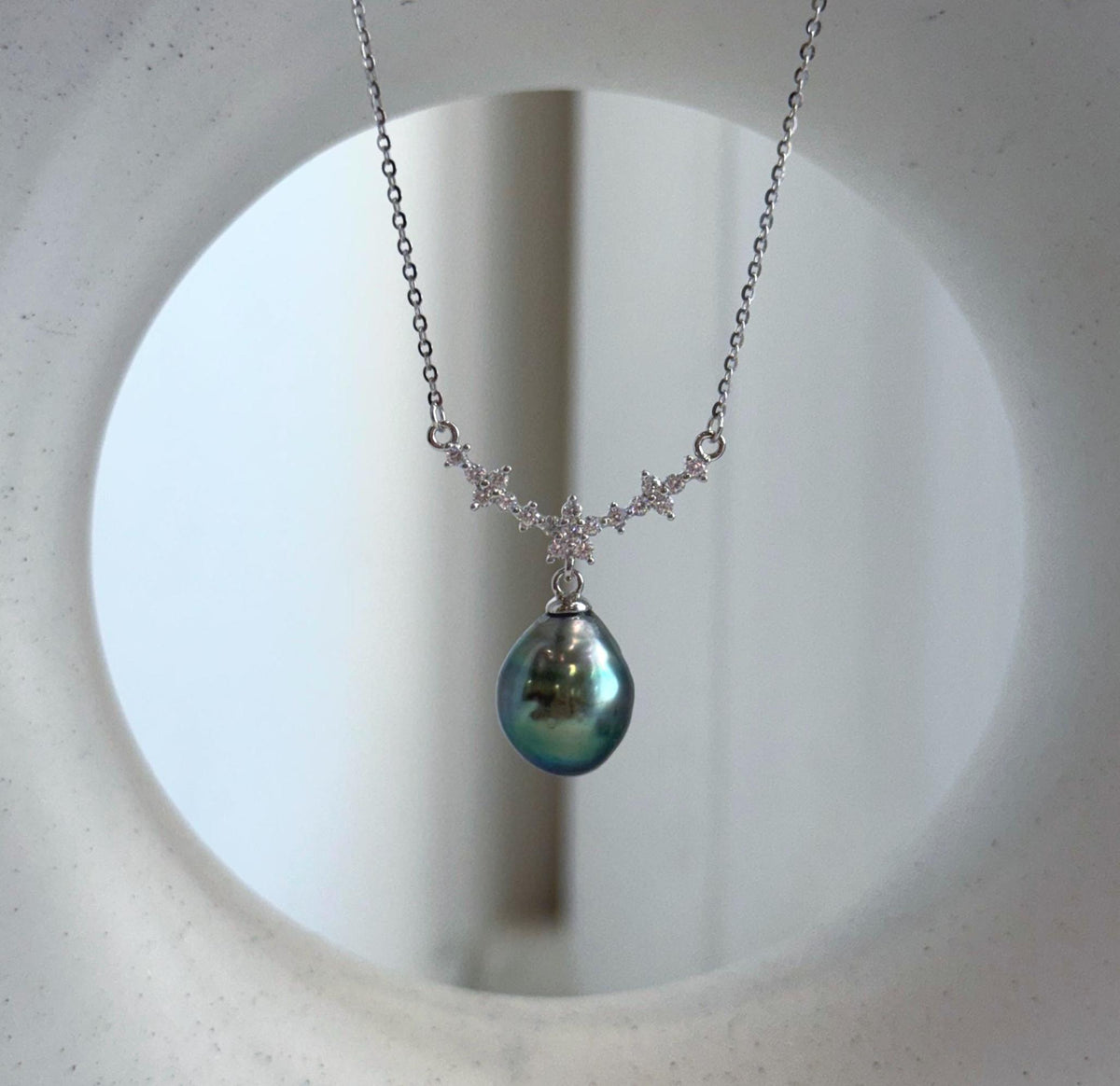 Peacock green Tahitian pearl necklace with a teardrop pearl beneath sparkling floral details in S925 sterling silver.