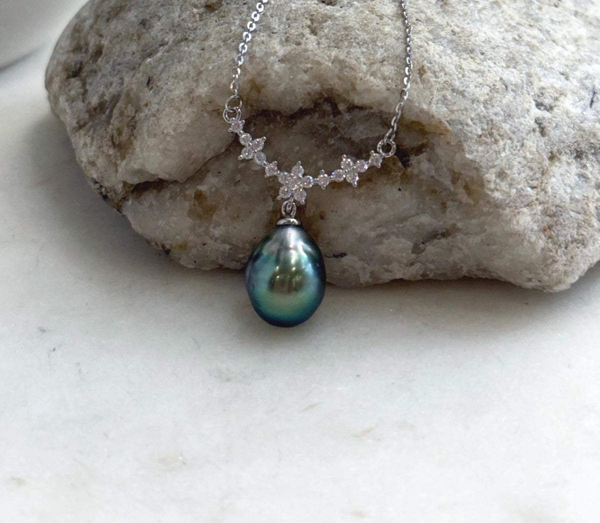 Genuine Tahitian saltwater pearl displaying deep green and blue overtones on a delicate sterling silver necklace.