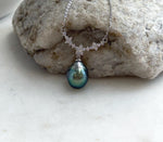 Genuine Tahitian saltwater pearl displaying deep green and blue overtones on a delicate sterling silver necklace.