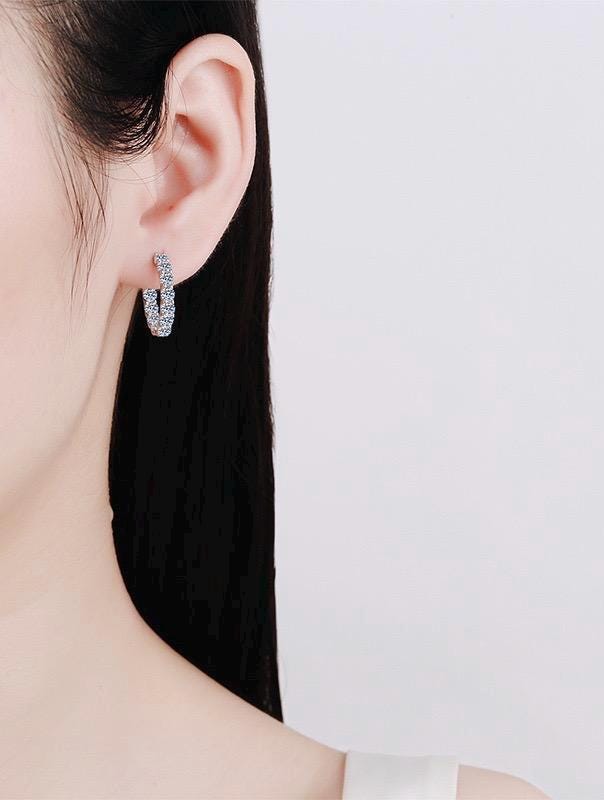 Inside out hoop earrings featuring round moissanite stones in silver settings.