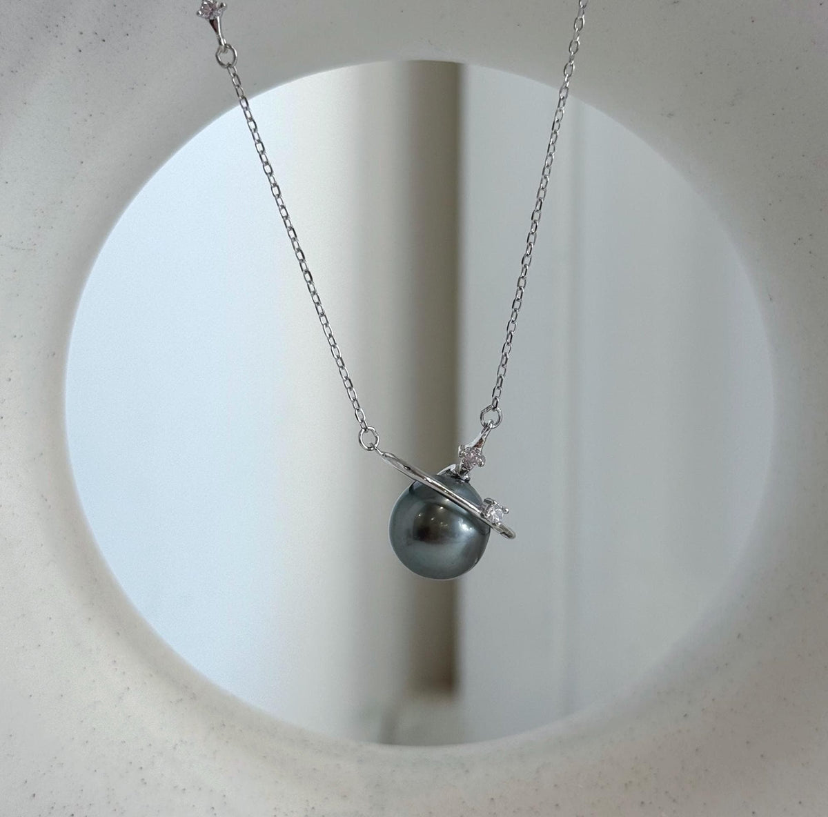 Genuine saltwater pearl necklace featuring a planet design with small star accents and a fine silver chain.