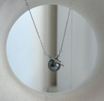 Lustrous green-gray Tahitian pearl framed by a polished silver ring with a sparkling accent.