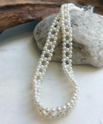 Woven pearl necklace featuring a delicate repeating diamond pattern.