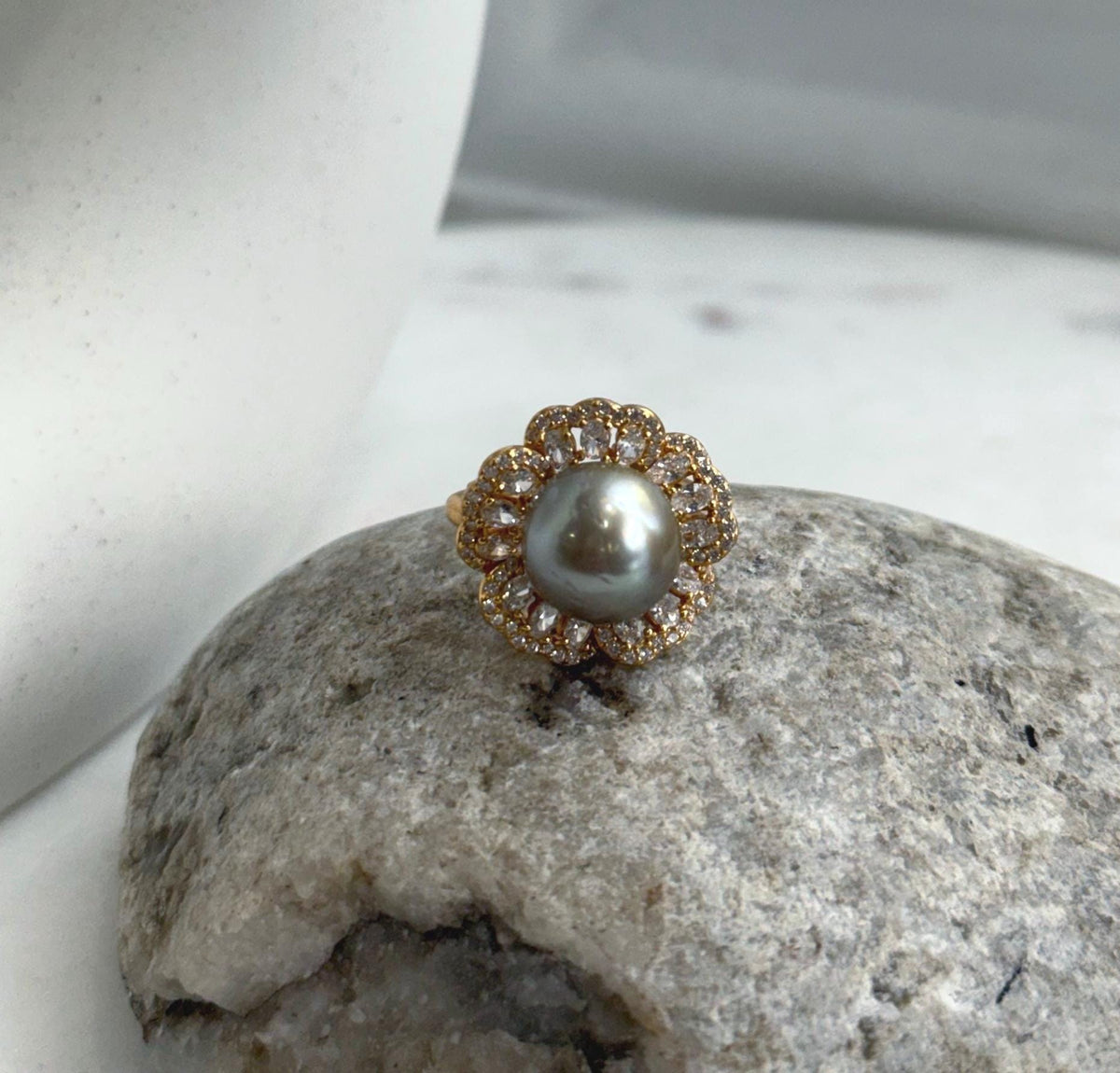 Lustrous taupe pearl surrounded by gold-plated sterling silver floral details.