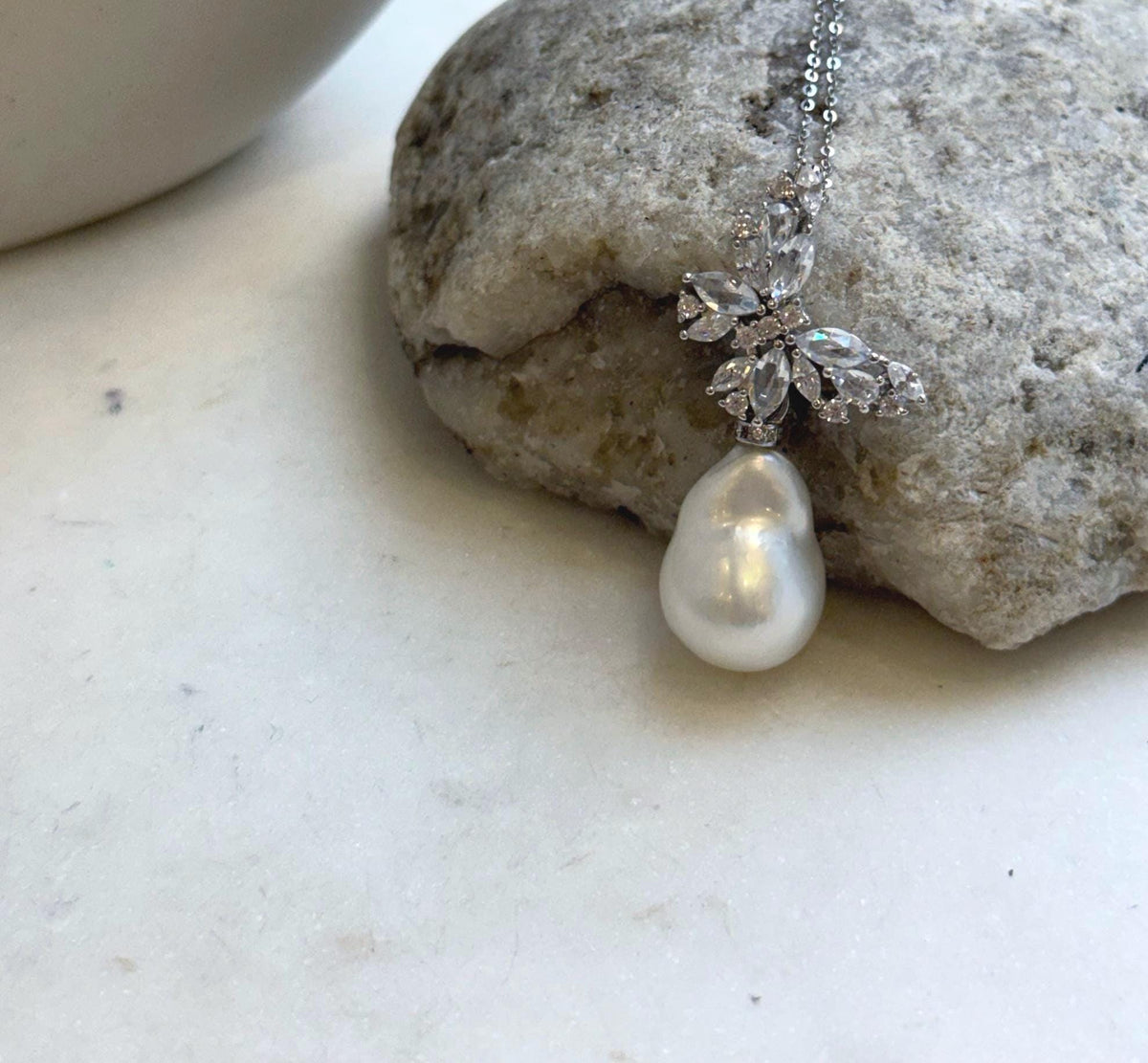 White ocean pearl with an organic baroque shape and silvery reflections.