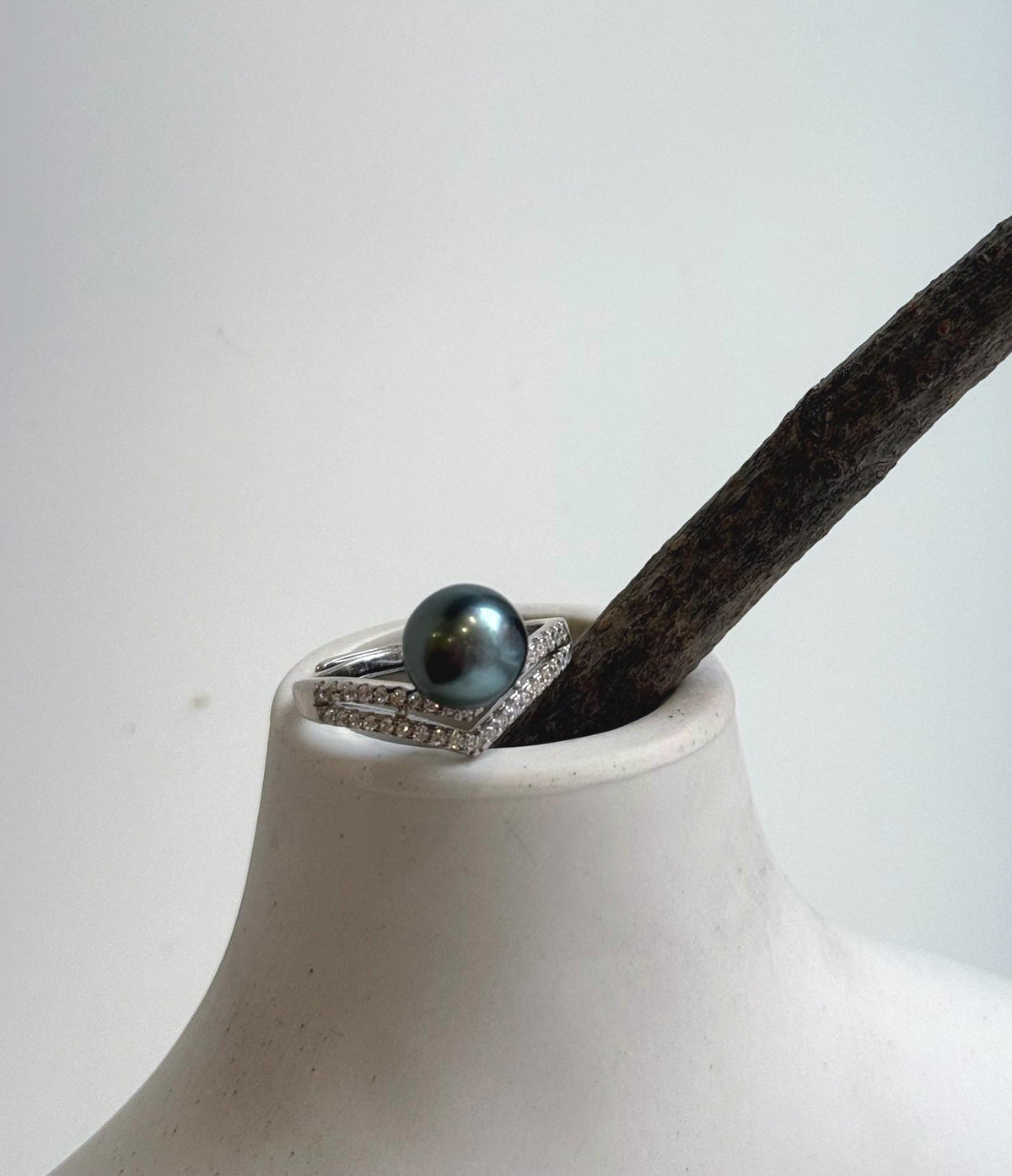 Green Tahitian pearl ring with two rows of clear accents along the shoulders.
