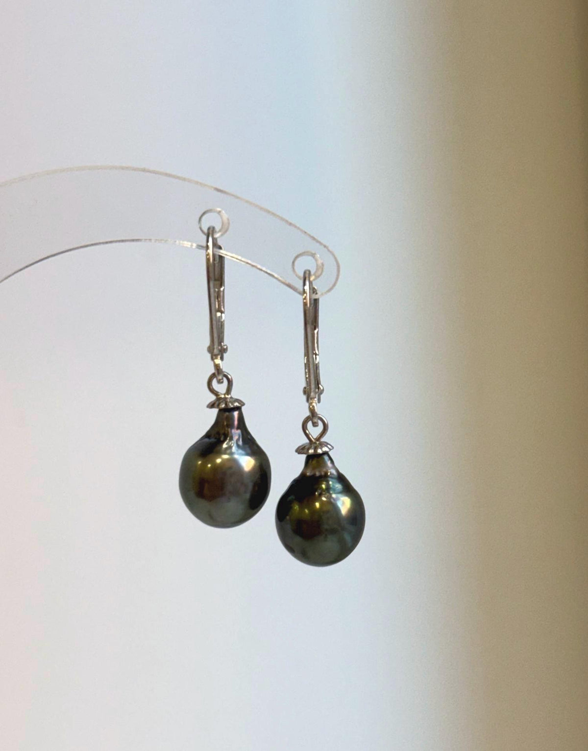 Genuine saltwater Tahitian pearl earrings with mirror luster and deep green tones.