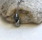 Two Tahitian pearls with mirror-like luster paired in a silver pendant necklace.