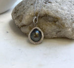 Tahitian keshi pearl necklace featuring a lustrous dark pearl and an embellished silver bail.