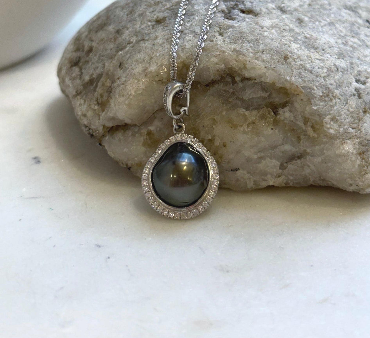 Tahitian keshi pearl necklace featuring a lustrous dark pearl and an embellished silver bail.