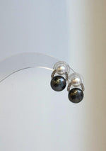 Dark and white pearl earrings with curved, sparkling sterling silver accents.