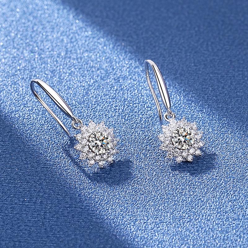 Floral moissanite earrings with polished silver hooks and delicate dangling settings.