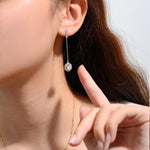 Moissanite halo earrings suspended from fine silver chains beneath sparkling curved tops.