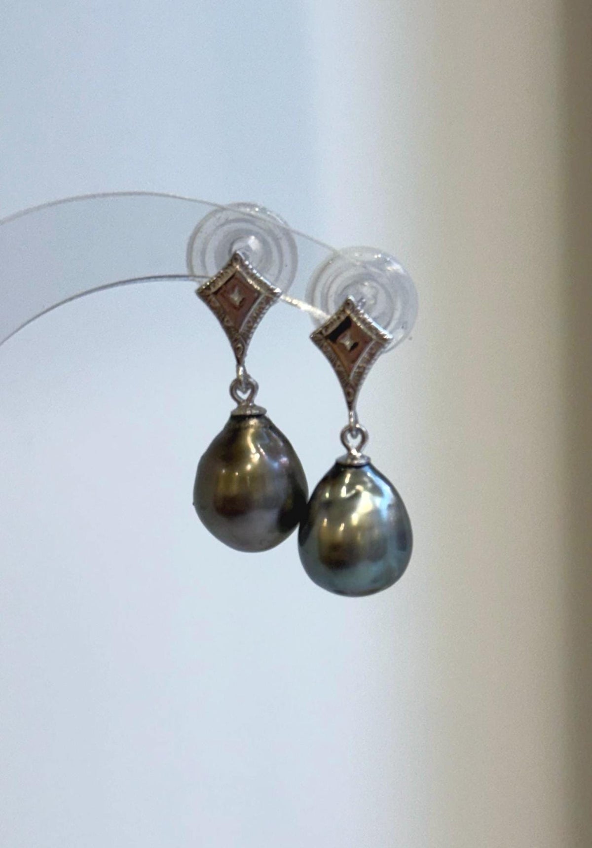 Lustrous Tahitian pearls suspended from diamond-shaped sterling silver stud settings.