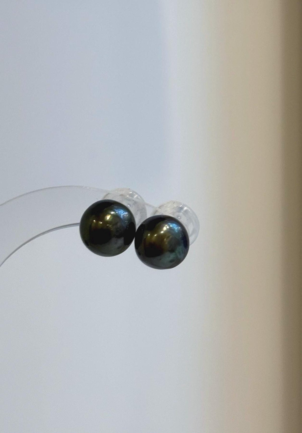 Hunter green pearl earrings with reflective surfaces and angular silver details.