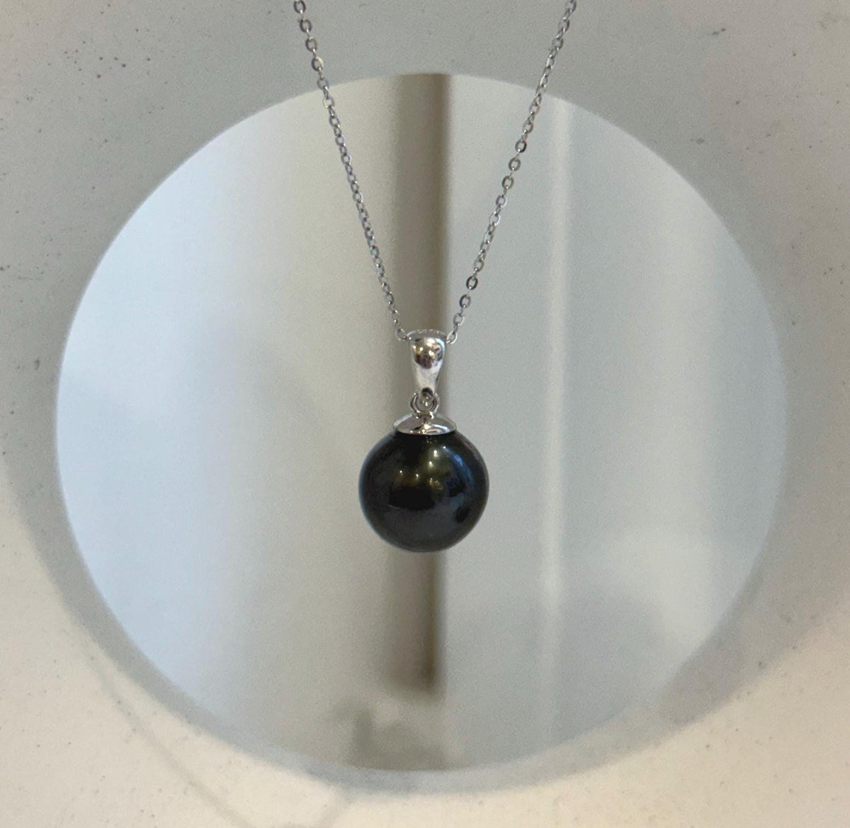 Piano black Tahitian pearl pendant with mirror luster and a minimalist S925 sterling silver setting.