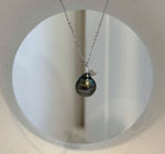 Tahitian pearl pendant suspended from a delicate silver chain with a sparkling leaf accent.