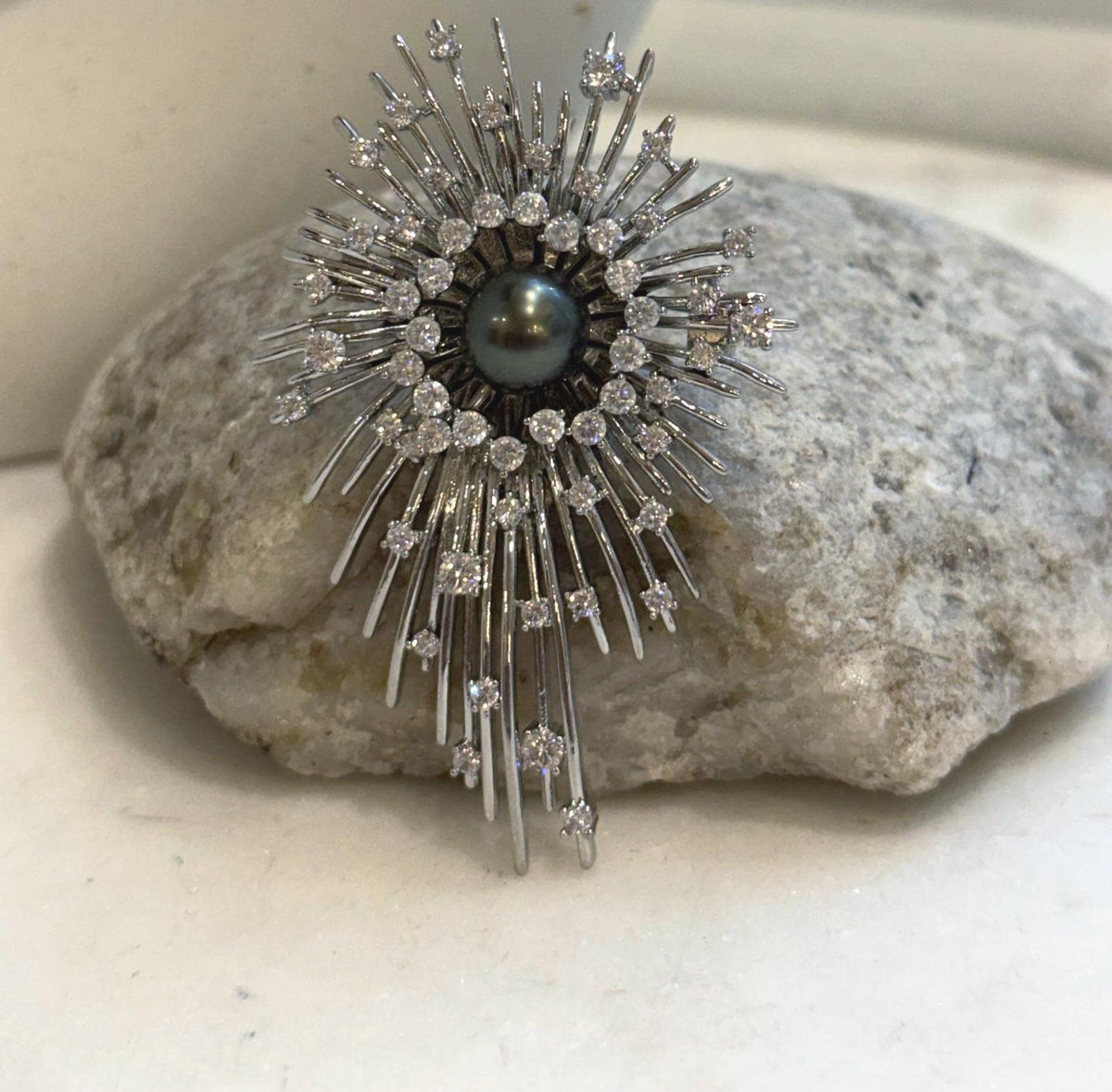 Black Tahitian pearl brooch pendant with a starburst design and mirror luster