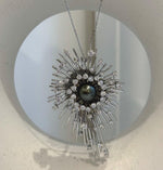Black saltwater pearl set within a statement starburst brooch pendant